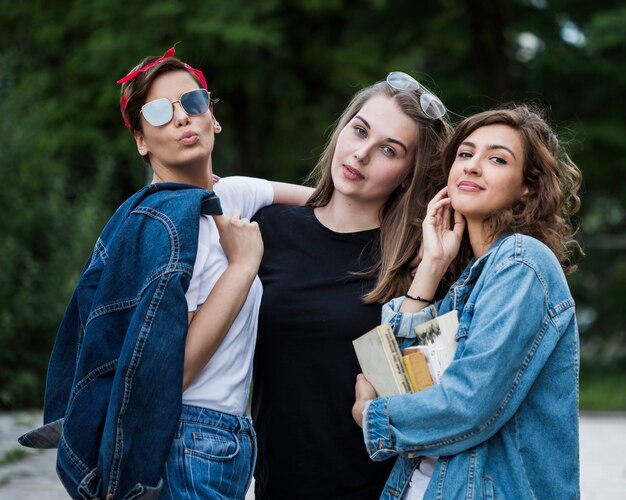 Lindas amigas de pie en el parque de verano