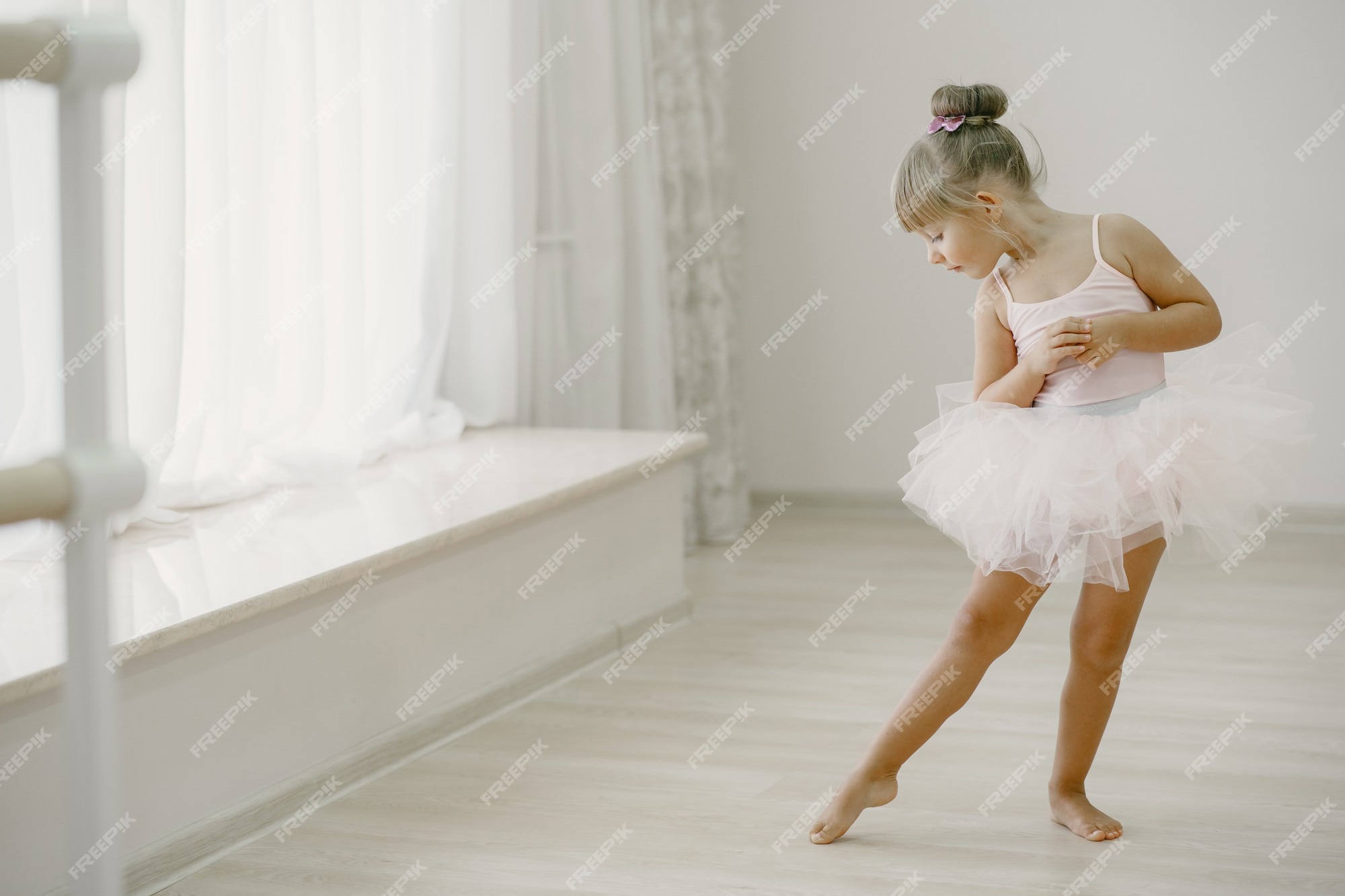 Lindas bailarinas en traje de ballet rosa. niño en zapatos de punta está bailando en la habitación. en clase de baile. | Foto Gratis