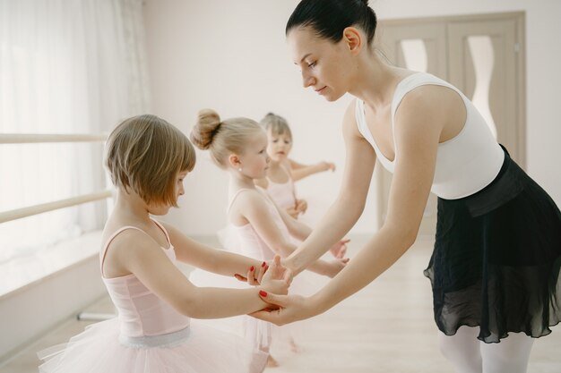 Lindas bailarinas en traje de ballet rosa. Los niños con zapatos de punta bailan en la habitación.