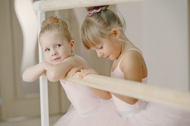 Lindas bailarinas en traje de ballet rosa. Los niños con zapatos de punta bailan en la habitación.