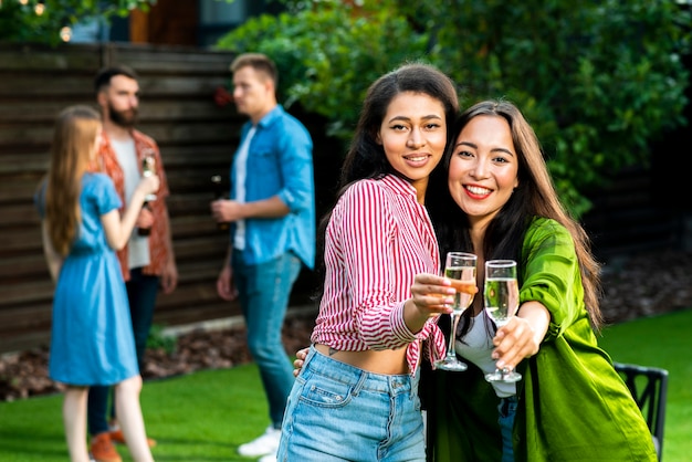 Foto gratuita lindas chicas jóvenes con bebidas mirando a cámara