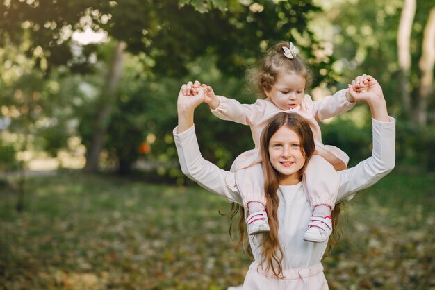 Lindas hermanitas jugando en un parque de primavera