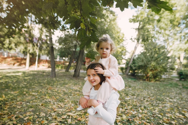 Lindas hermanitas jugando en un parque de primavera