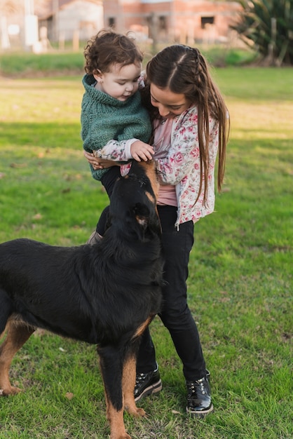 Foto gratuita lindas hermanitas jugando con su perro en el suelo