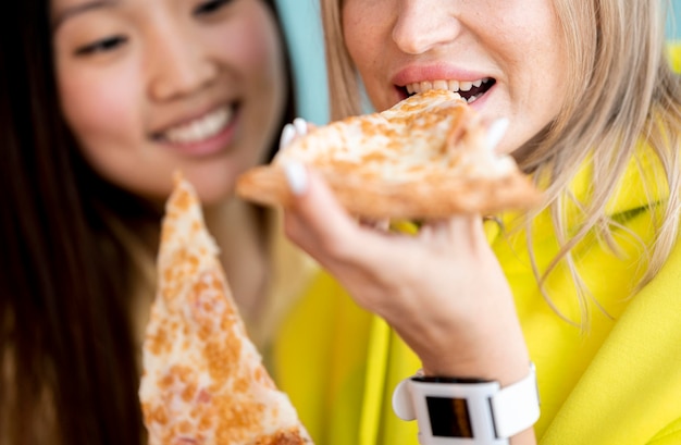 Lindas mujeres asiáticas comiendo pizza