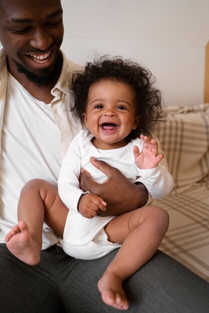 Lindo bebé negro en casa con sus padres