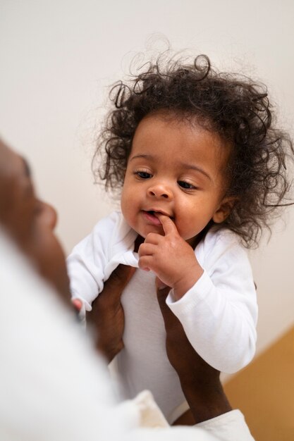 Lindo bebé negro en casa con sus padres