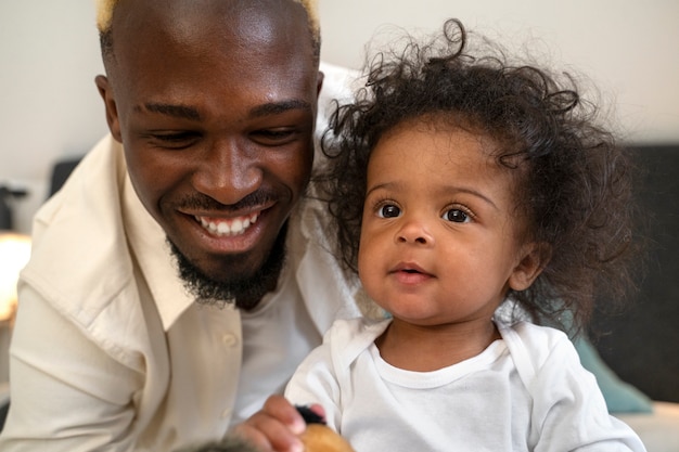 Lindo bebé negro en casa con sus padres