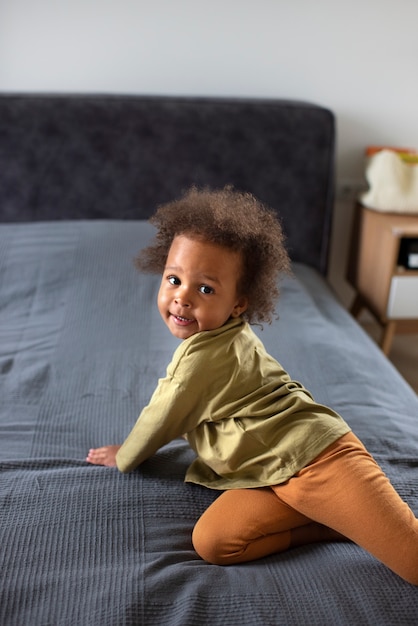 Foto gratuita lindo bebé negro divirtiéndose en casa