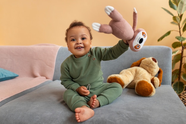 Foto gratuita lindo bebé con peluche