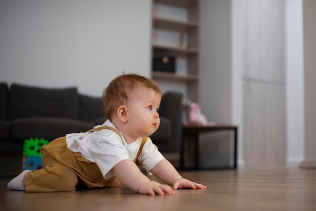 Foto gratuita lindo bebé de tiro completo acostado en el piso