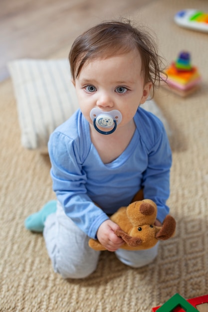 Foto gratuita lindo bebé de tiro completo con chupete