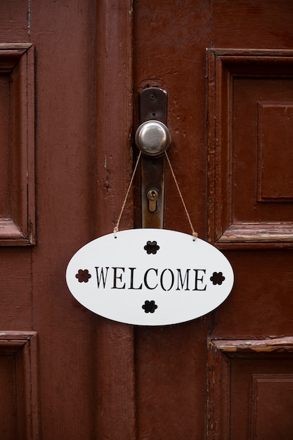 Lindo cartel de bienvenida en la puerta de madera