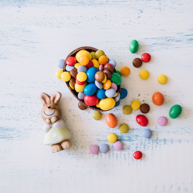 Foto gratuita lindo conejito cerca de dulces de pascua