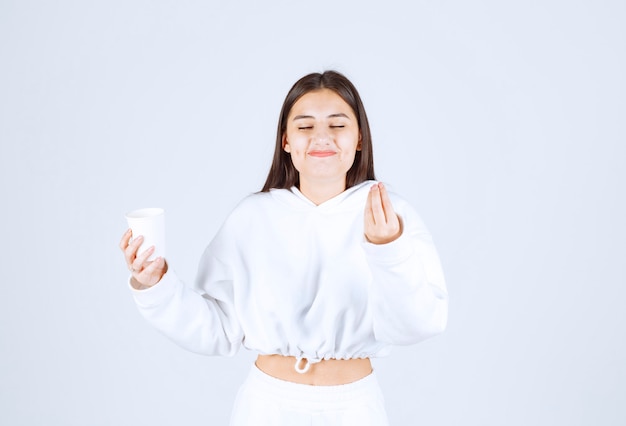 lindo modelo de niña sosteniendo un vaso de plástico.