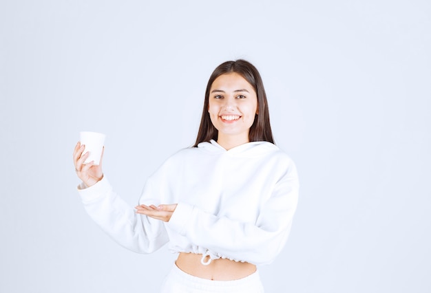 lindo modelo de niña sosteniendo un vaso de plástico.