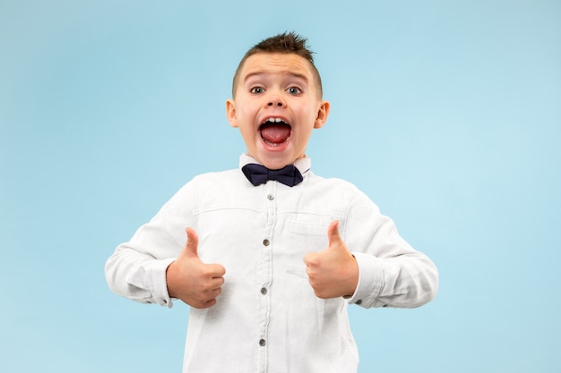 Foto gratuita lindo muchacho adolescente elegante sobre fondo azul. expresión emocional