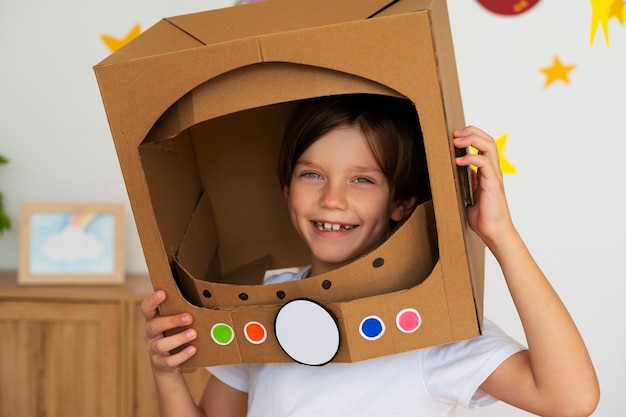 Foto gratuita lindo niño astronauta jugando