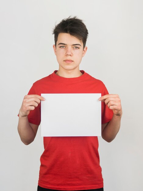 Lindo niño en camiseta roja con un espacio de copia en papel