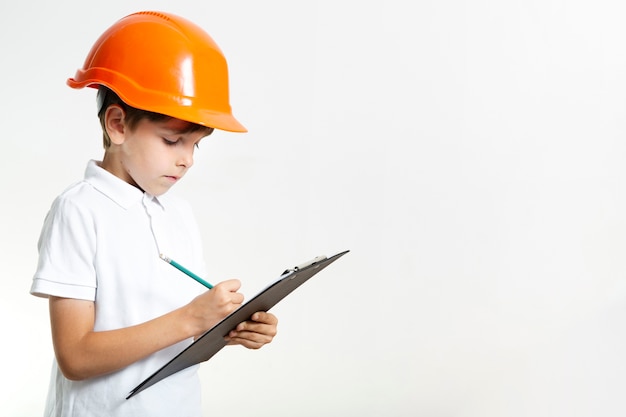 Foto gratuita lindo niño con casco escribiendo