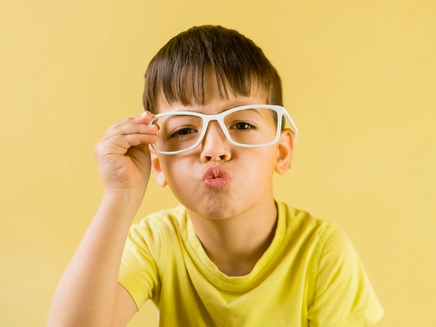 Lindo niño con gafas y sopla un beso