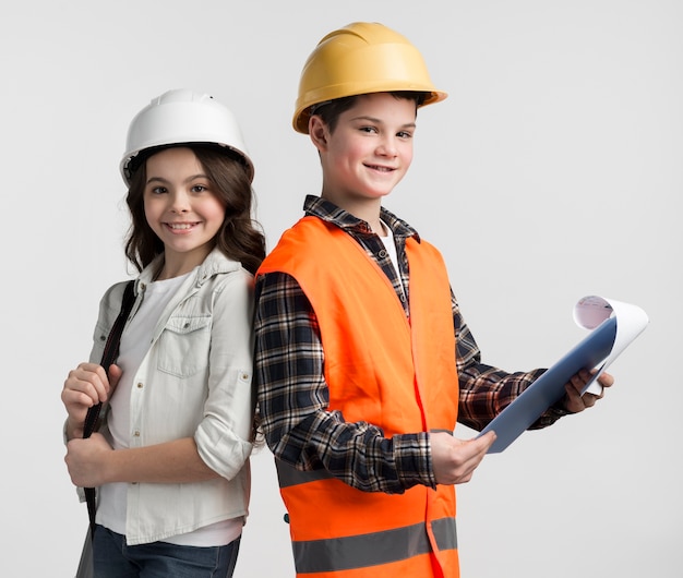 Lindo niño y una niña haciéndose pasar por ingenieros