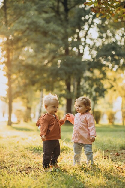 Lindo niño y niña juntos en el parque otoñal