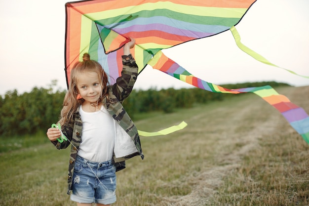 Lindo niño pequeño en un campo de verano con una cometa