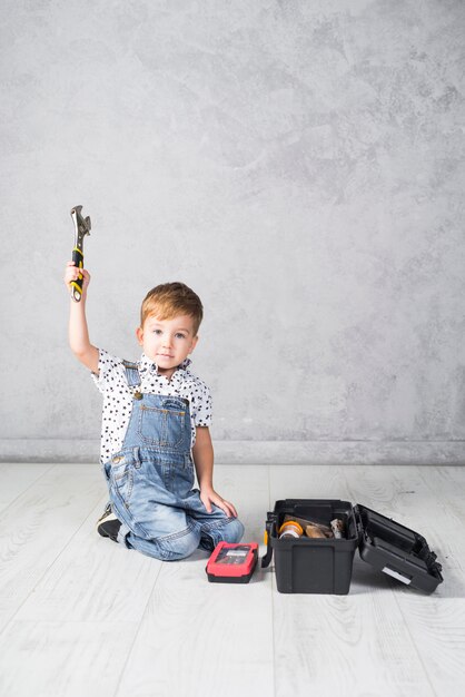 Lindo niño sentado con llave inglesa