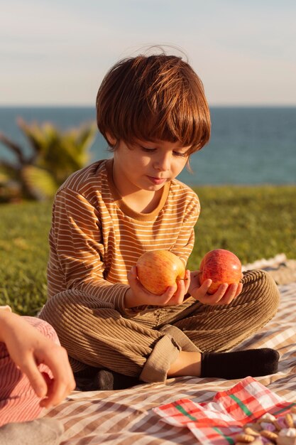 Lindo niño sosteniendo manzanas