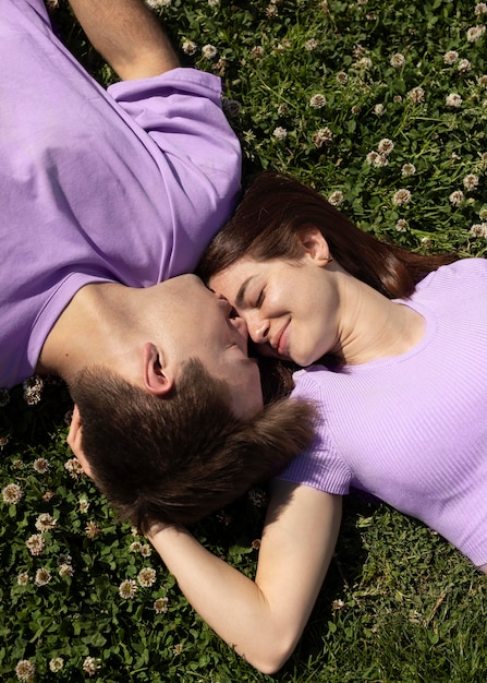 Lindo novio y novia tumbado en el césped