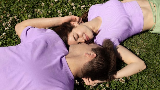 Lindo novio y novia tumbado en el césped