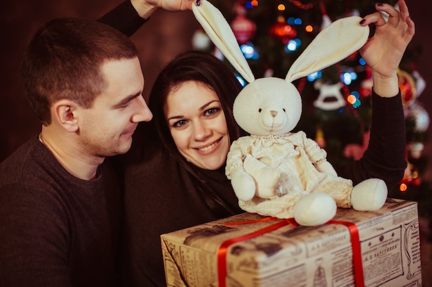 lindo pareja sosteniendo decoraciones de Navidad y regalo