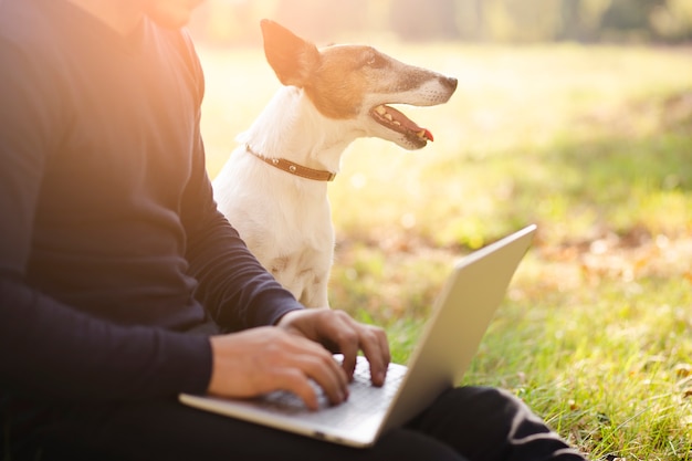 Lindo perro con dueño y laptop