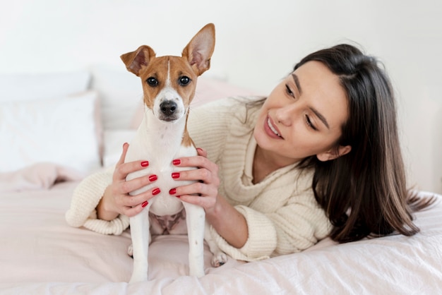 Lindo perro posando mientras está en manos de una mujer