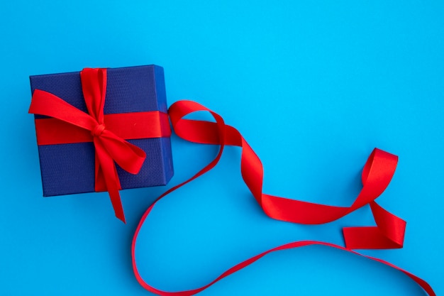 Lindo regalo azul y rojo con cintas.