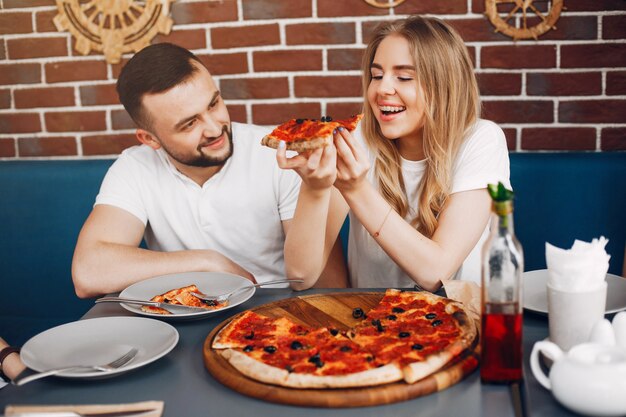 Lindos amigos en una cafetería comiendo una pizza