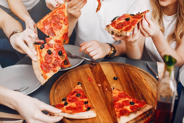 Lindos amigos en una cafetería comiendo una pizza