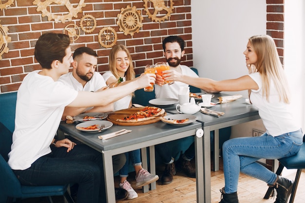 Lindos amigos en una cafetería comiendo una pizza