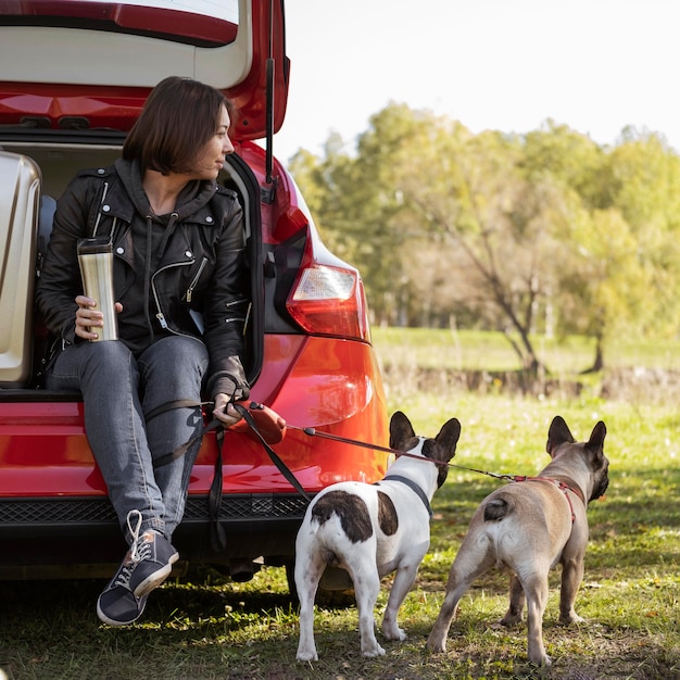 Lindos cachorros y mujer sentada en el coche