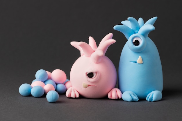 Foto gratuita lindos monstruos de plastilina azul y rosa