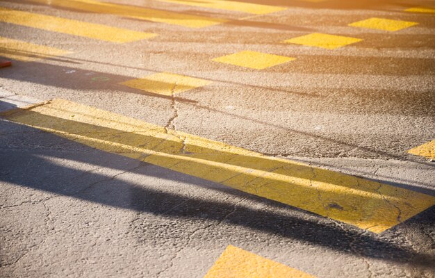 Línea de pintura amarilla en la textura de la superficie de la carretera de asfalto negro