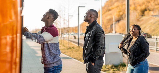 Línea de tiro medio de personas negras pidiendo en camión de comida