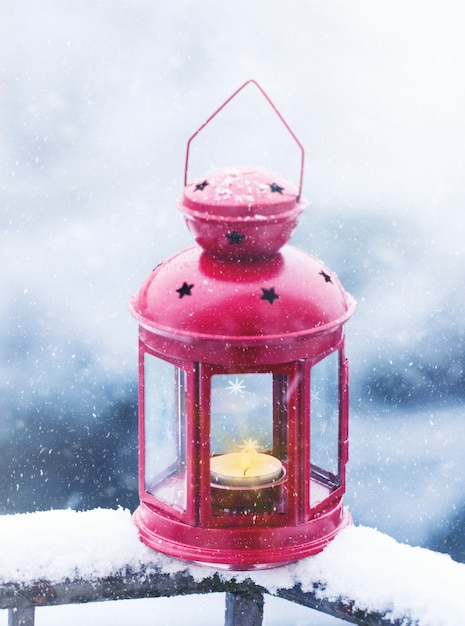 Linterna de la vela de Navidad en un fondo cubierto de nieve fuera, concepto de Navidad
