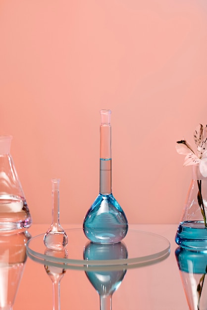 Líquido azul en cristalería de laboratorio con fondo rosa.