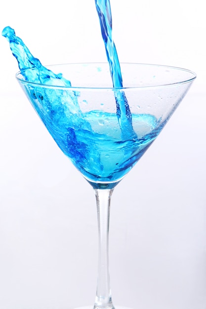 Líquido azul vertiendo en vidrio