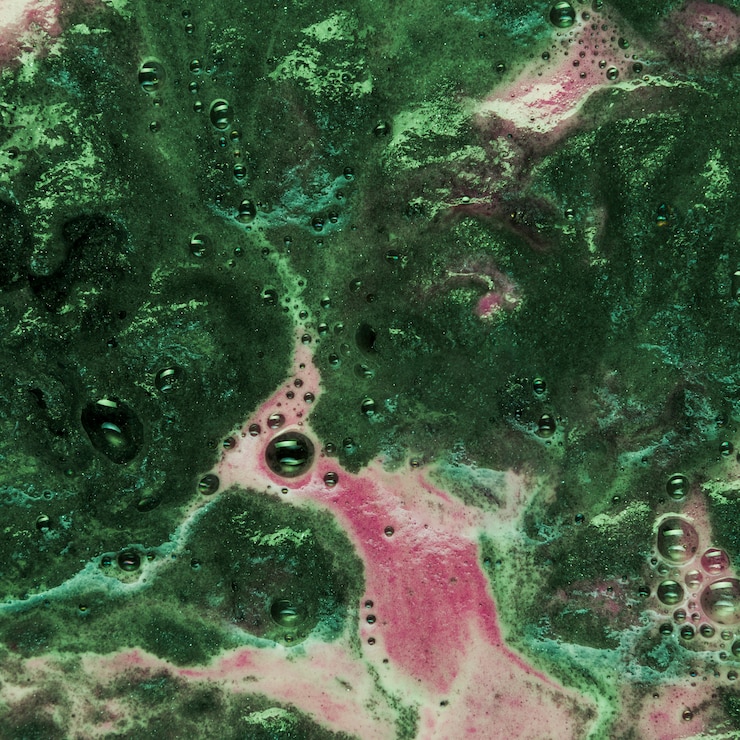 Foto gratuito líquido verde con espuma rosa.