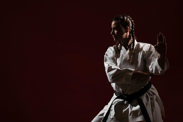 Foto gratuita listo para luchar contra la mujer en uniforme de karate blanco