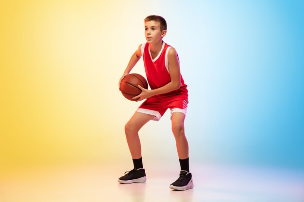 Listo. Retrato de joven jugador de baloncesto en uniforme en pared degradada