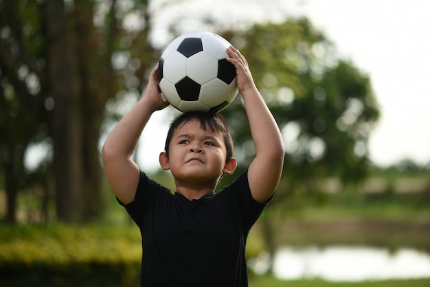 Little boy mano sosteniendo fútbol soccer